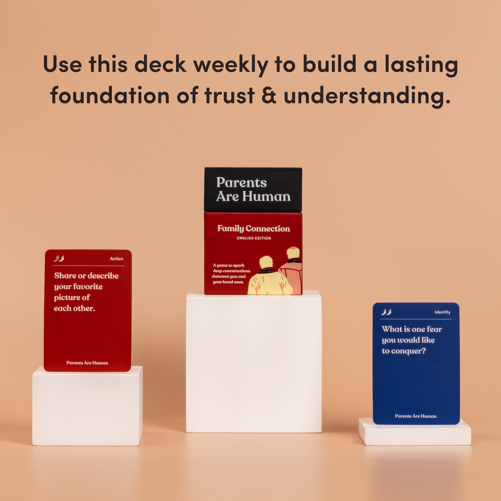 Parents Are Human Family Connection box, English Edition, on a pedestal between two cards, tan background