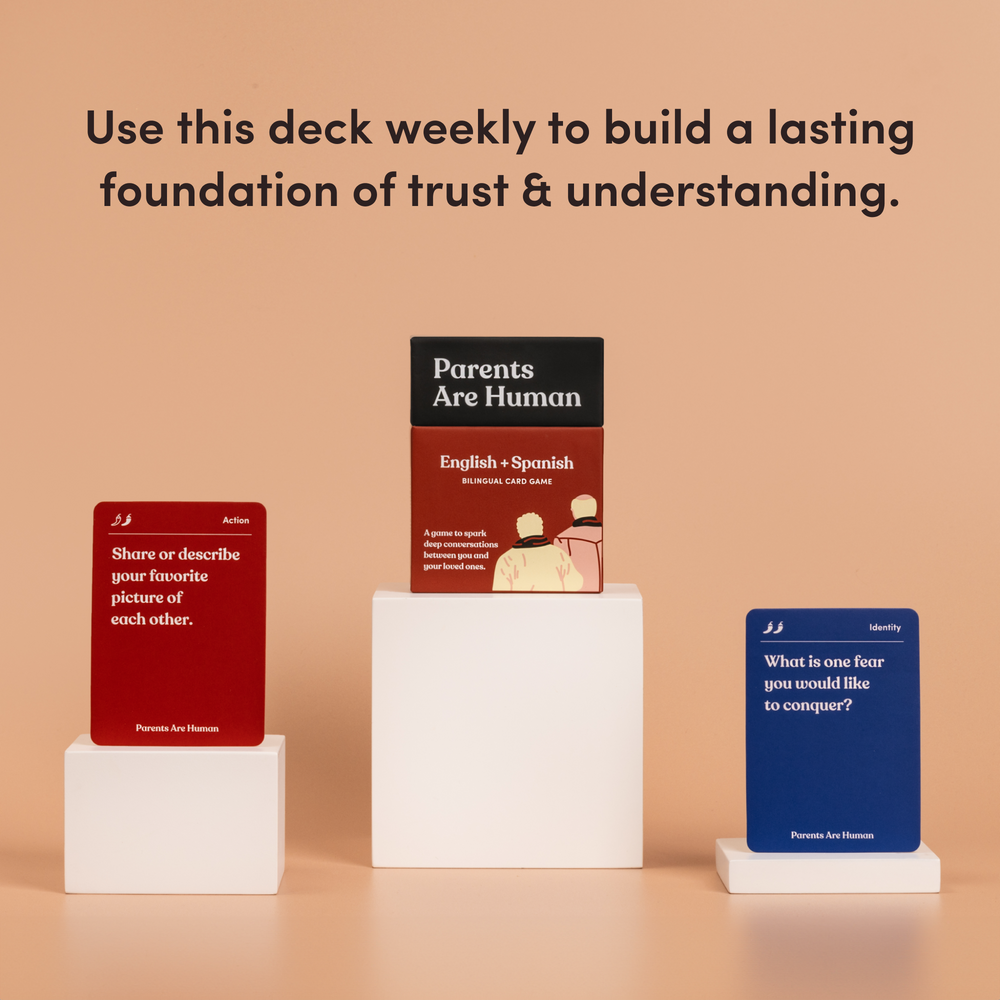 Parents Are Human English + Spanish box on a pedestal between two cards, tan background