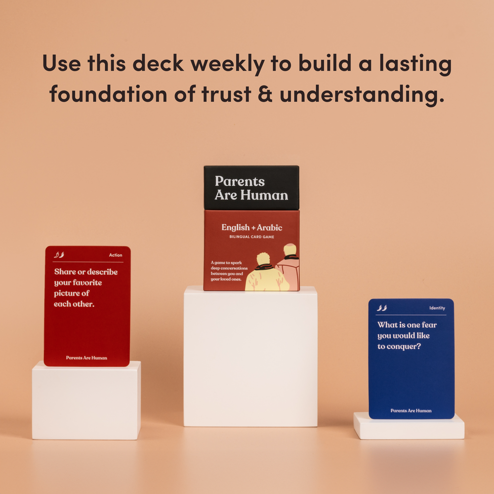 Parents Are Human English + Arabic box on a pedestal between two cards, tan background