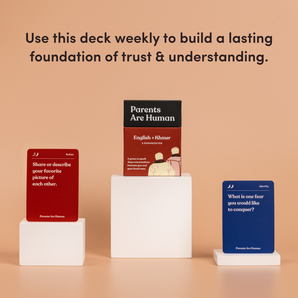 Parents Are Human English + Khmer box on a pedestal between two cards, tan background