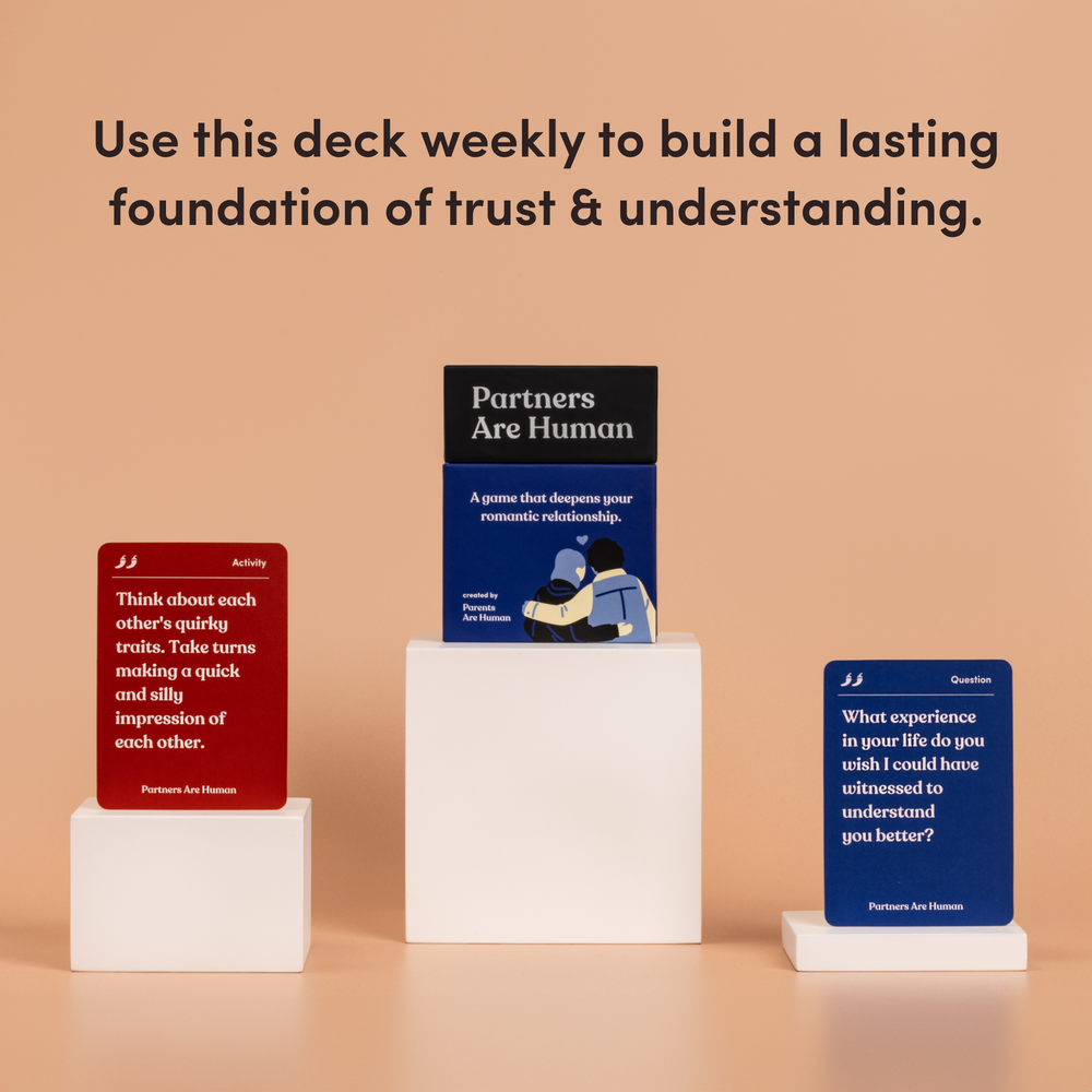 Partners Are Human box on a pedestal between a red activity card and a blue question card, on a peach background