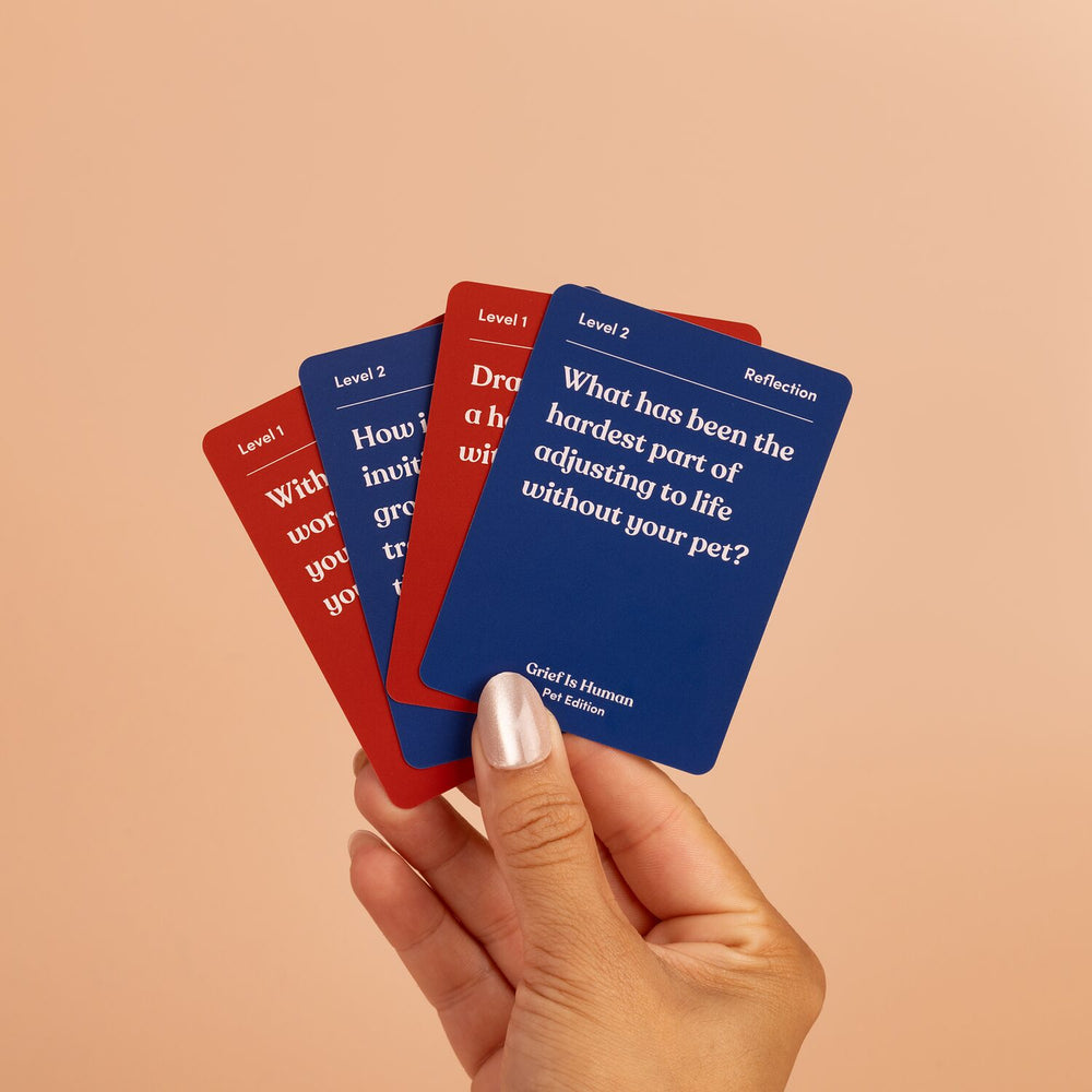 Hand fanning Grief Is Human Pet Edition cards: "What has been the hardest part of adjusting to life without your pet?"